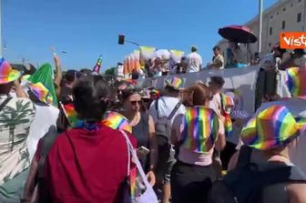 'Maschera da cane con bandiera con l'immagine di un osso al Pride a Roma