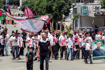 I fedeli musulmani sciiti marciano in processione davanti agli edifici distrutti dai bombardamenti israeliani a Nabatieh, nel Libano meridionale, il 26 giugno 2026
