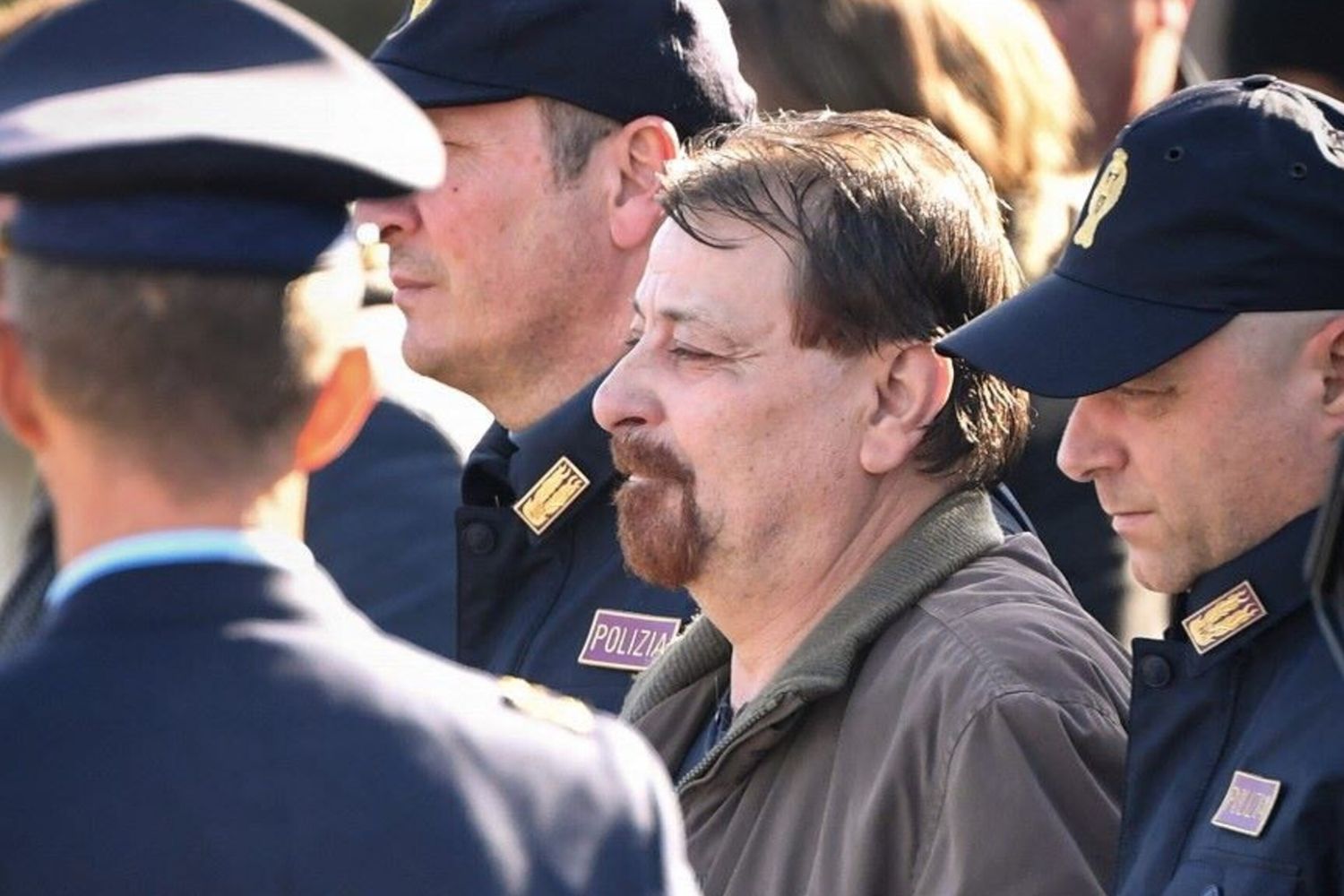 Cesare Battisti viene scortato da agenti della polizia  - immagine del 14 gennaio 2019
