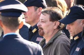 Cesare Battisti viene scortato da agenti della polizia  - immagine del 14 gennaio 2019