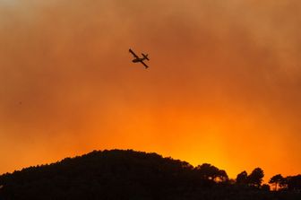 Un Canadair in volo sul rogo di Calci