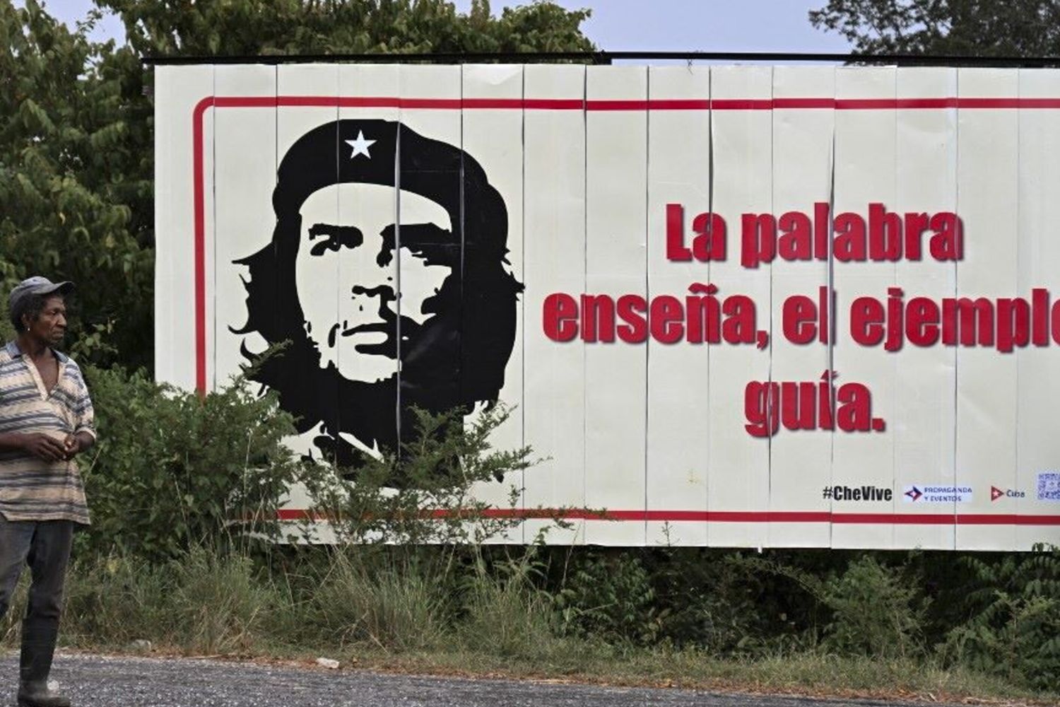 Un cubano  a fianco di un manifesto di Ernesto "Che" Guevara a Vinales