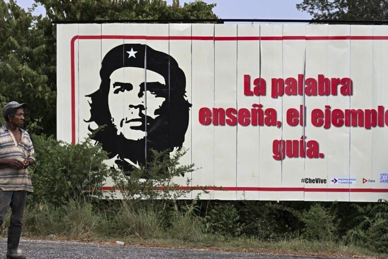 Un cubano  a fianco di un manifesto di Ernesto "Che" Guevara a Vinales