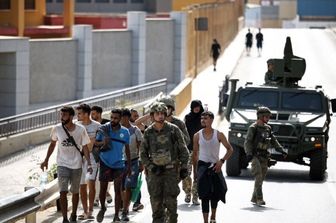 I migranti scortati dalla polizia spagnola al confine con il Marocco