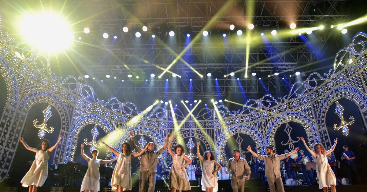 Un palco in piazza a Melpignano, con spettatori e artisti, durante la Notte della Taranta