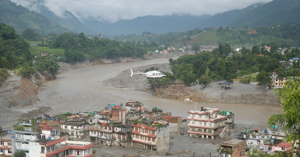 Colata di detriti e acqua travolge abitazioni e veicoli lungo il fiume