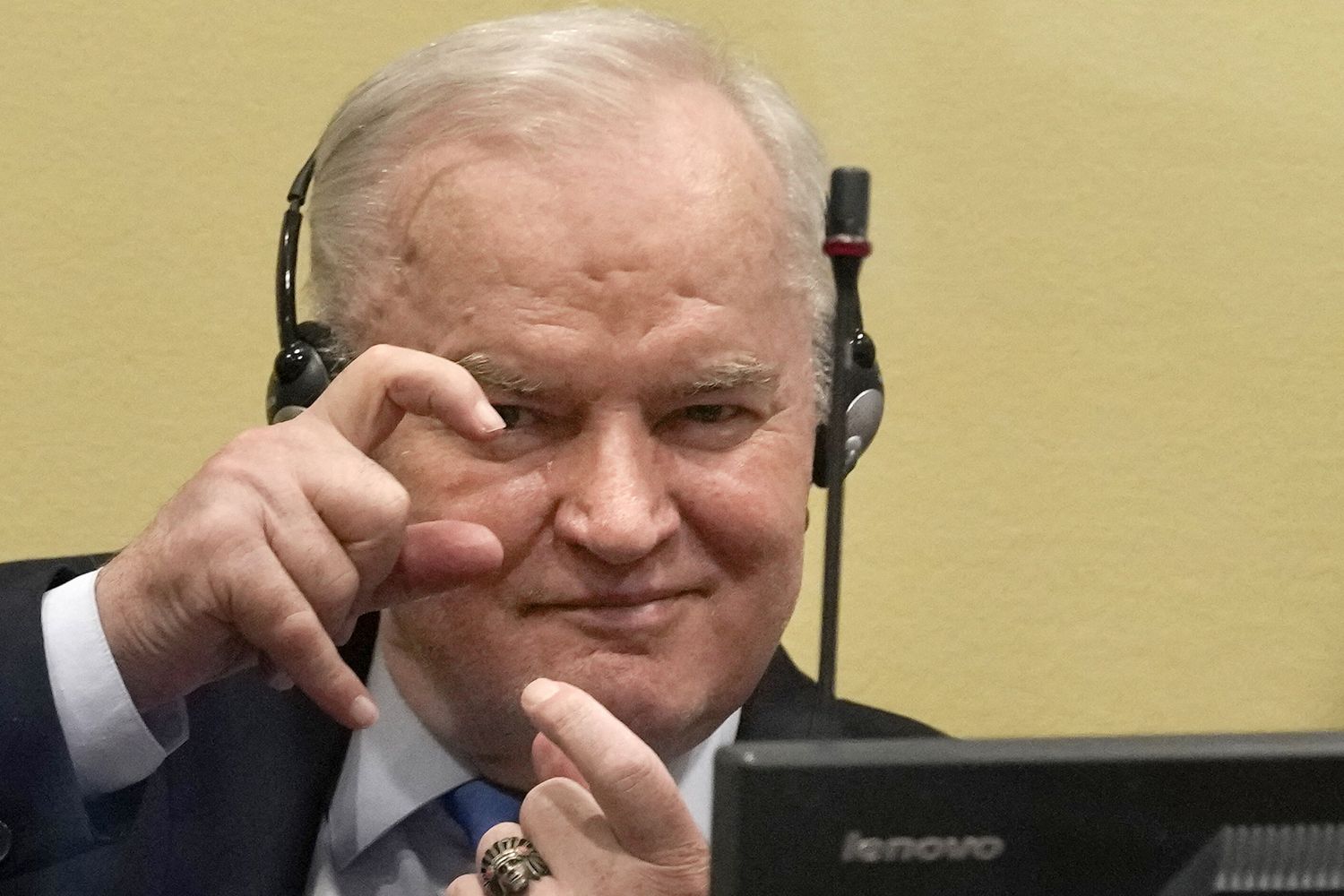 Mladic imita i fotografi durante il processo al Tribunale dell'Aja
