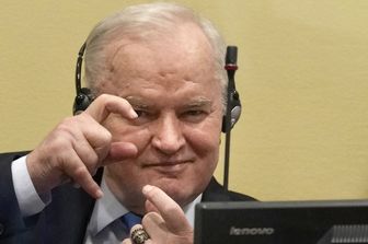 Mladic imita i fotografi durante il processo al Tribunale dell'Aja