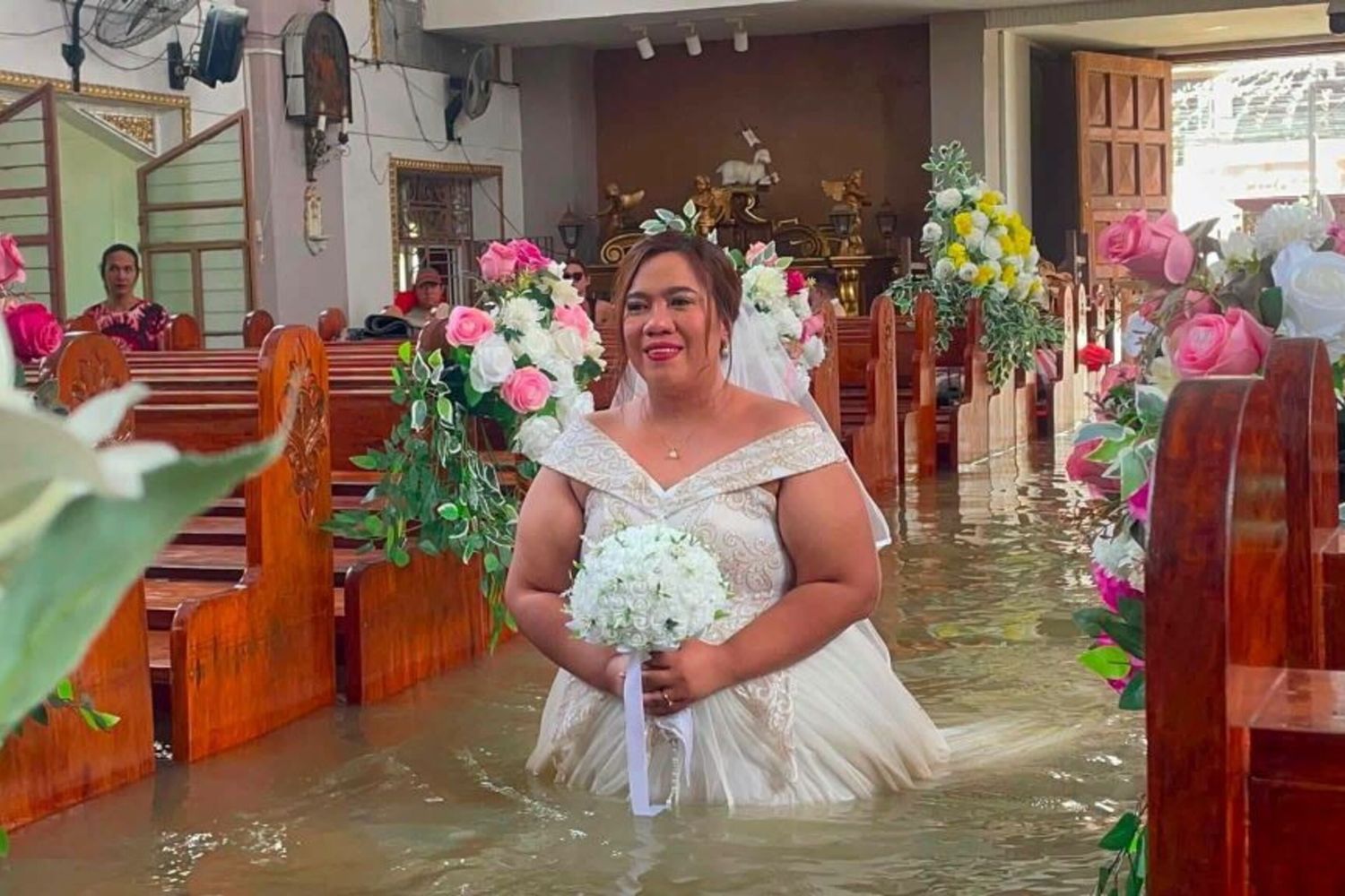 La sposa nella chiesa delle Filippine invasa dall'acqua