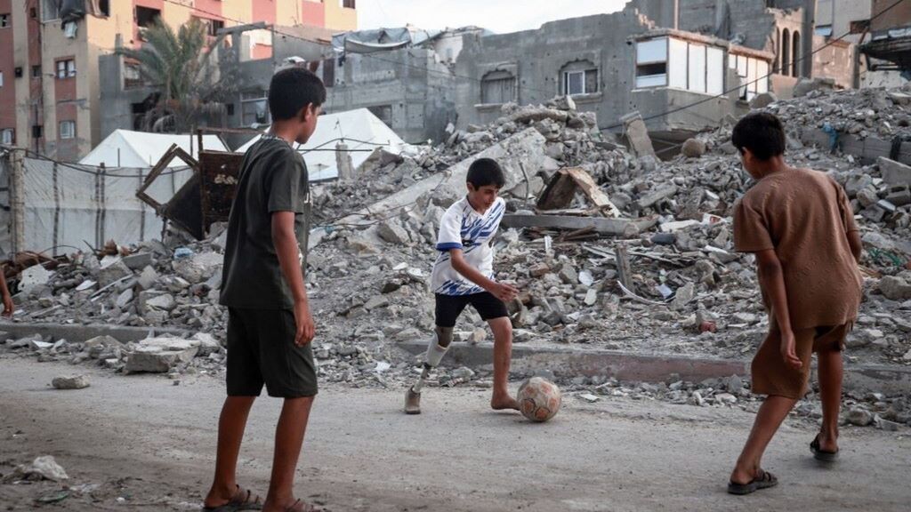 Ragazzini giocano a calcio tra i palazzi crollati a Gaza  - immagine del 24 settembre 2026