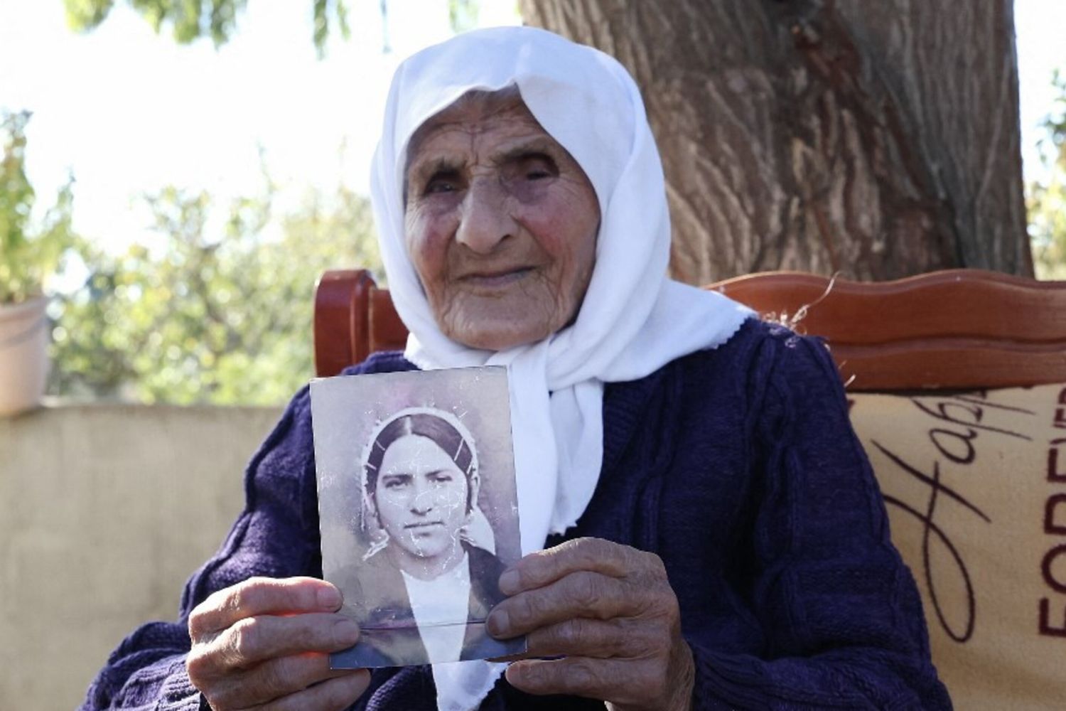 Qamile Marra, 117 anni, tiene in mano una fotografia in bianco e nero della sua giovinezza