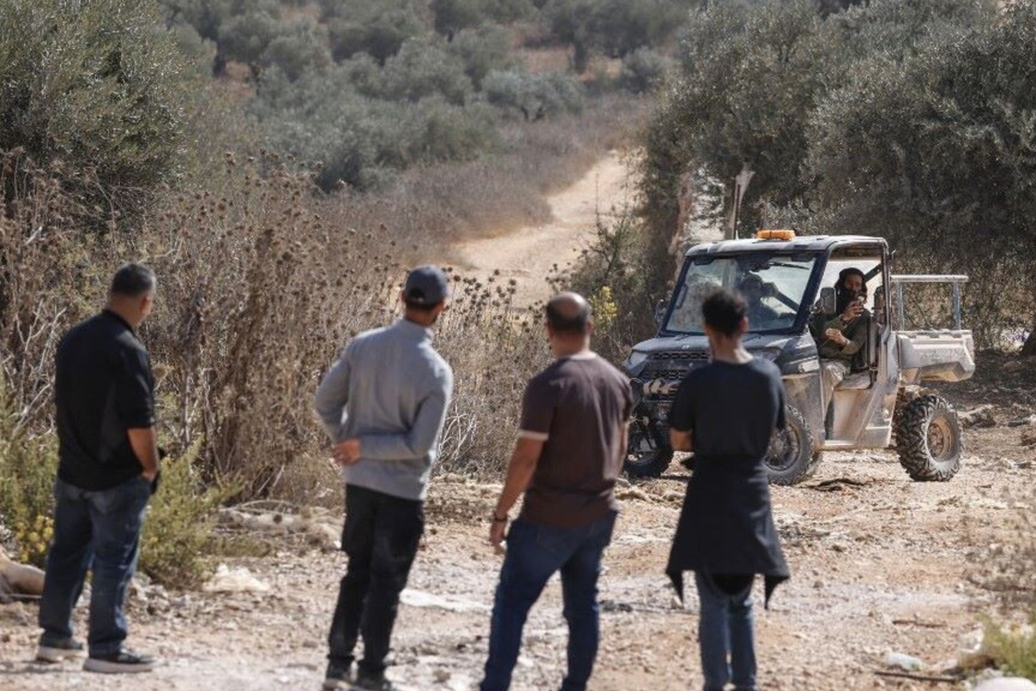 Agricoltori palestinesi fotografati da un colono israeliano