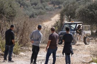 Agricoltori palestinesi fotografati da un colono israeliano